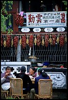 Women eat outside the Snack Food in Lijiang restaurant. Lijiang, Yunnan, China