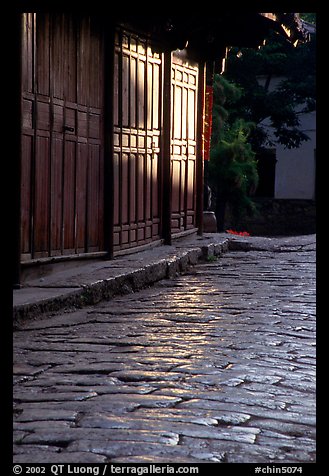 Cobblestone street and wooden doors at sunrise. Lijiang, Yunnan, China