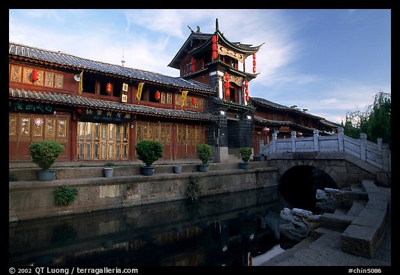 Kegong tower (memorial archway of imperial exam) reflected in canal, sunrise. Lijiang, Yunnan, China (color)