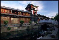 Kegong tower (memorial archway of imperial exam) reflected in canal, sunrise. Lijiang, Yunnan, China ( color)