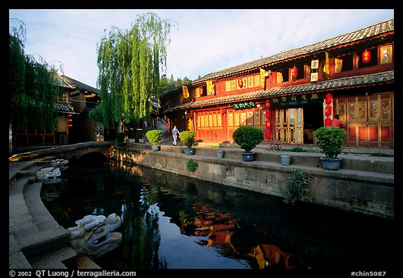 Buildings on Square street reflected in canal, sunrise. Lijiang, Yunnan, China