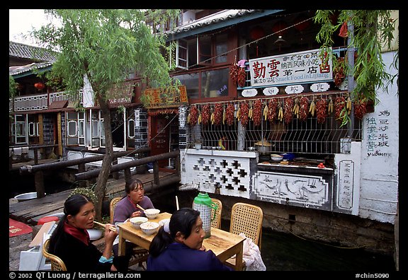 Women eat outside the Snack Food in Lijiang restaurant. Lijiang, Yunnan, China