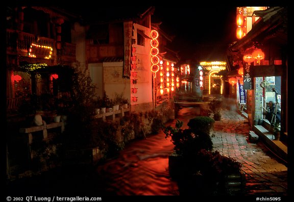 Red lanterns reflected in a canal at night. Lijiang, Yunnan, China (color)