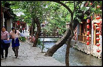 Naxi women walk along a canal. Lijiang, Yunnan, China (color)