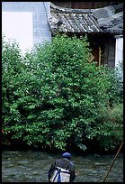 Naxi woman sitting next to a canal. Lijiang, Yunnan, China ( color)