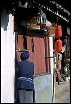 Naxi woman at the door of her wooden house. Lijiang, Yunnan, China