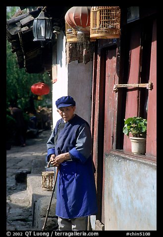 Naxi woman at the door of her wooden house. Lijiang, Yunnan, China (color)