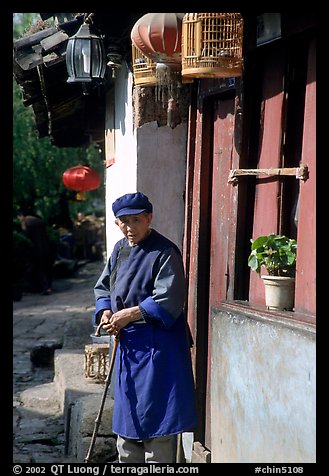 Naxi woman at the door of her wooden house. Lijiang, Yunnan, China