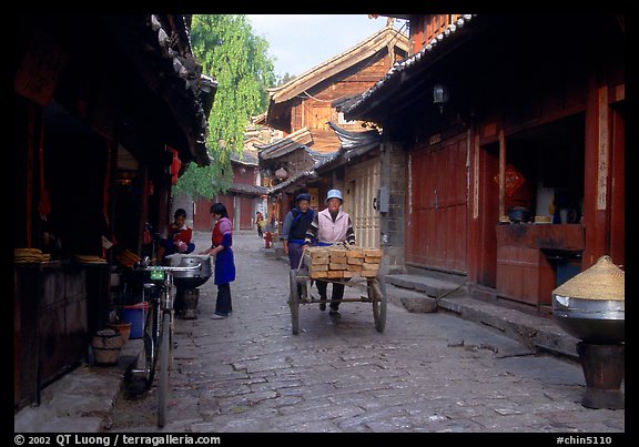 Early morning activity in a cobblestone street. Lijiang, Yunnan, China (color)