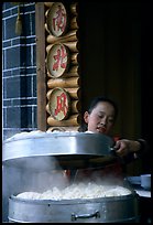 Woman baking dumplings. Lijiang, Yunnan, China