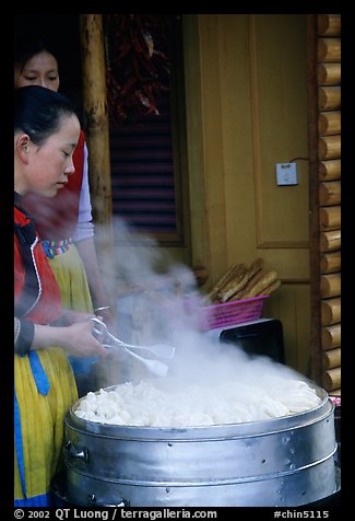 Naxi Women baking dumplings. Lijiang, Yunnan, China (color)