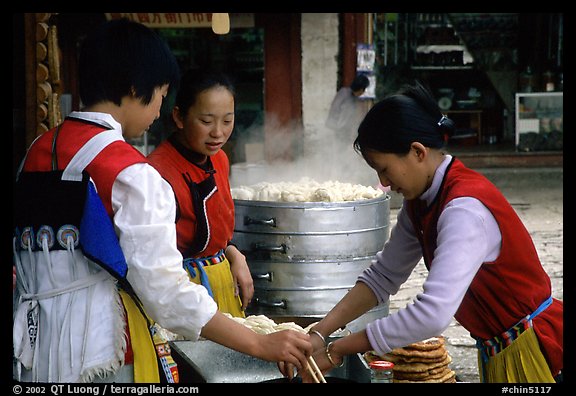 Naxi Women preparing the baba flatbreat. Lijiang, Yunnan, China