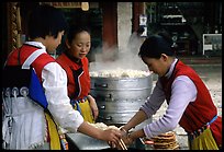 Naxi Women preparing the baba flatbreat. Lijiang, Yunnan, China (color)