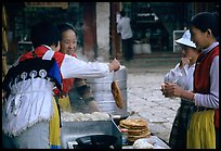 Naxi Women preparing the baba flatbreat. Lijiang, Yunnan, China (color)