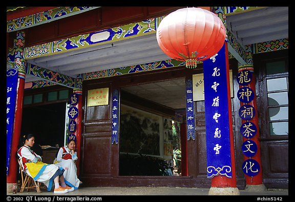 Women sit ouside  the Wufeng Lou (Five Phoenix Hall). Lijiang, Yunnan, China (color)