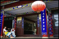 Women sit ouside  the Wufeng Lou (Five Phoenix Hall). Lijiang, Yunnan, China