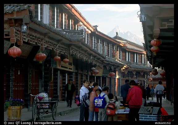 Schoolchildren get Naxi flatbread for breakfast, Jade Dragon Snow Mountain in the background. Lijiang, Yunnan, China