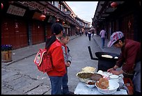 Schoolchildren get Naxi flatbread for breakfast. Lijiang, Yunnan, China