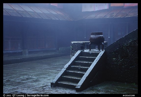 Urn and stairs in courtyard of Xiangfeng temple in fog. Emei Shan, Sichuan, China