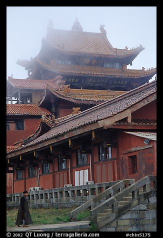 Monk beneath Jinding Si (Golden Summit) temple in the fog. Emei Shan, Sichuan, China