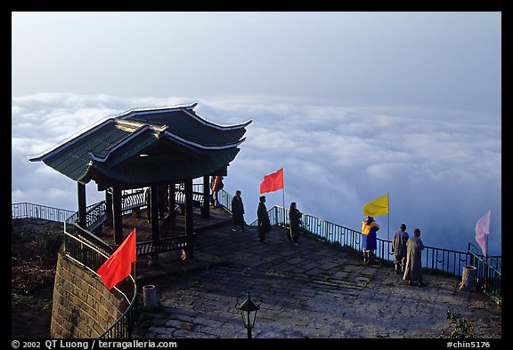 Monks and pilgrims admiring a sea of cloud from the summit. Emei Shan, Sichuan, China (color)