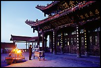 Pilgrim prays in the Jinding Si (Golden Summit) temple at dusk. Emei Shan, Sichuan, China ( color)