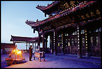 Pilgrim prays in the Jinding Si (Golden Summit) temple at dusk. Emei Shan, Sichuan, China