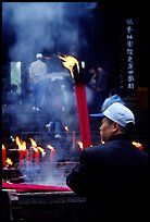 Pilgrim offering big incense stick. Emei Shan, Sichuan, China