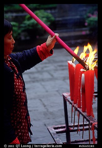 Woman Pilgrim lighting a large incense stick, Wannian Si. Emei Shan, Sichuan, China