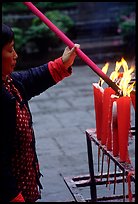 Woman Pilgrim lighting a large incense stick, Wannian Si. Emei Shan, Sichuan, China (color)