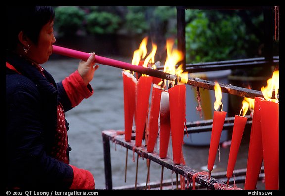 Woman Pilgrim lighting a large incense stick, Wannian Si. Emei Shan, Sichuan, China (color)