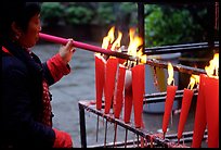 Woman Pilgrim lighting a large incense stick, Wannian Si. Emei Shan, Sichuan, China (color)