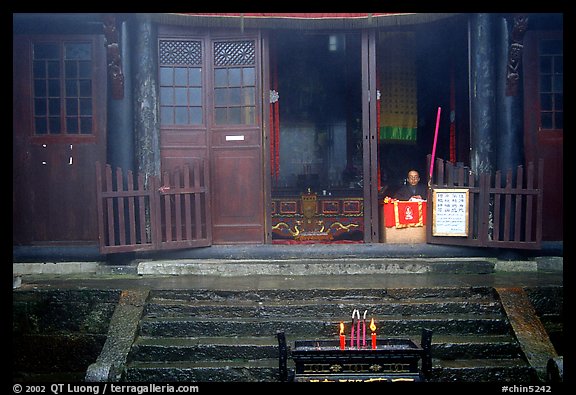 Monk looks to the courtyard inside Xixiangchi temple. Emei Shan, Sichuan, China