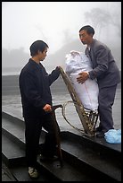 Porter getting ready to carry a heavy load on a back frame. Emei Shan, Sichuan, China