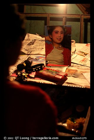 Sichuan opera actress checks her hair in a mirror. Chengdu, Sichuan, China