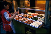 Woman helping herself to food. Sichuan food is among China's spiciest. Chengdu, Sichuan, China ( color)