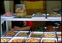 Vendor taking a nap at a food stall.. Chengdu, Sichuan, China