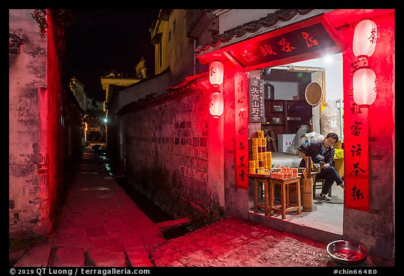 Shopkeeper and alley at night. Hongcun Village, Anhui, China