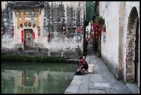 Woman washes laundry in Moon Pond. Hongcun Village, Anhui, China