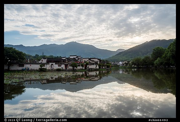 Village and clouds reflected in South Lake. Hongcun Village, Anhui, China