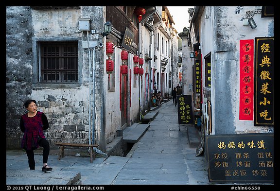 Woman standing next to main street. Xidi Village, Anhui, China (color)