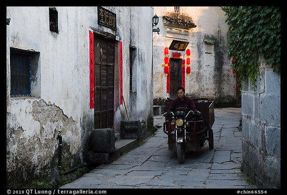Man driving motobike carriage in narrow street. Xidi Village, Anhui, China