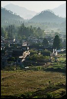 Villagers in fields and village in morning fog from above. Xidi Village, Anhui, China ( color)