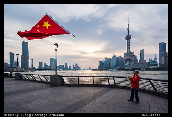 Man flying kite with Chinese flag attached on line, the Bund. Shanghai, China (color)