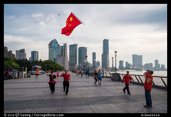 Joggers salute Chinese flag flown on kite line, the Bund. Shanghai, China (color)