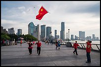 Joggers salute Chinese flag flown on kite line, the Bund. Shanghai, China ( color)