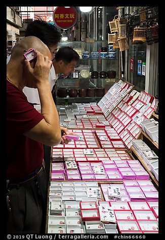 Man listening at insect. Shanghai, China (color)