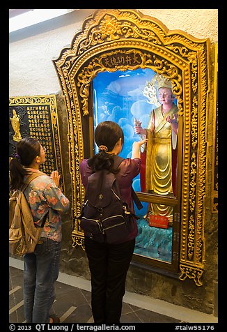 Women pray to deity, Guandu Temple. Taipei, Taiwan