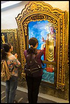 Women pray to deity, Guandu Temple. Taipei, Taiwan ( color)