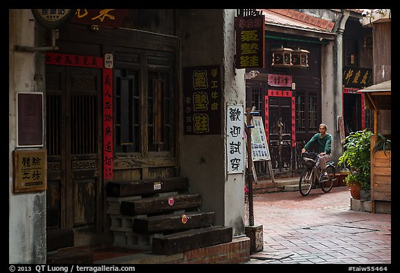 Man on bicycle amidst old houses in alley. Lukang, Taiwan